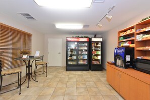 A reception area with a reception desk, two refrigerators stocked with beverages, and a coffee machine. - Candlewood Suites Gillette by IHG (Gillette)