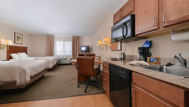 A hotel room with two beds, a desk, a television, a microwave, a coffee maker, and a sink. - Candlewood Suites Gillette by IHG (Gillette)