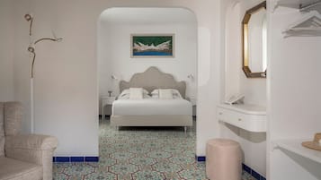 A bedroom with a bed, a nightstand, a mirror, and a wall-mounted picture.