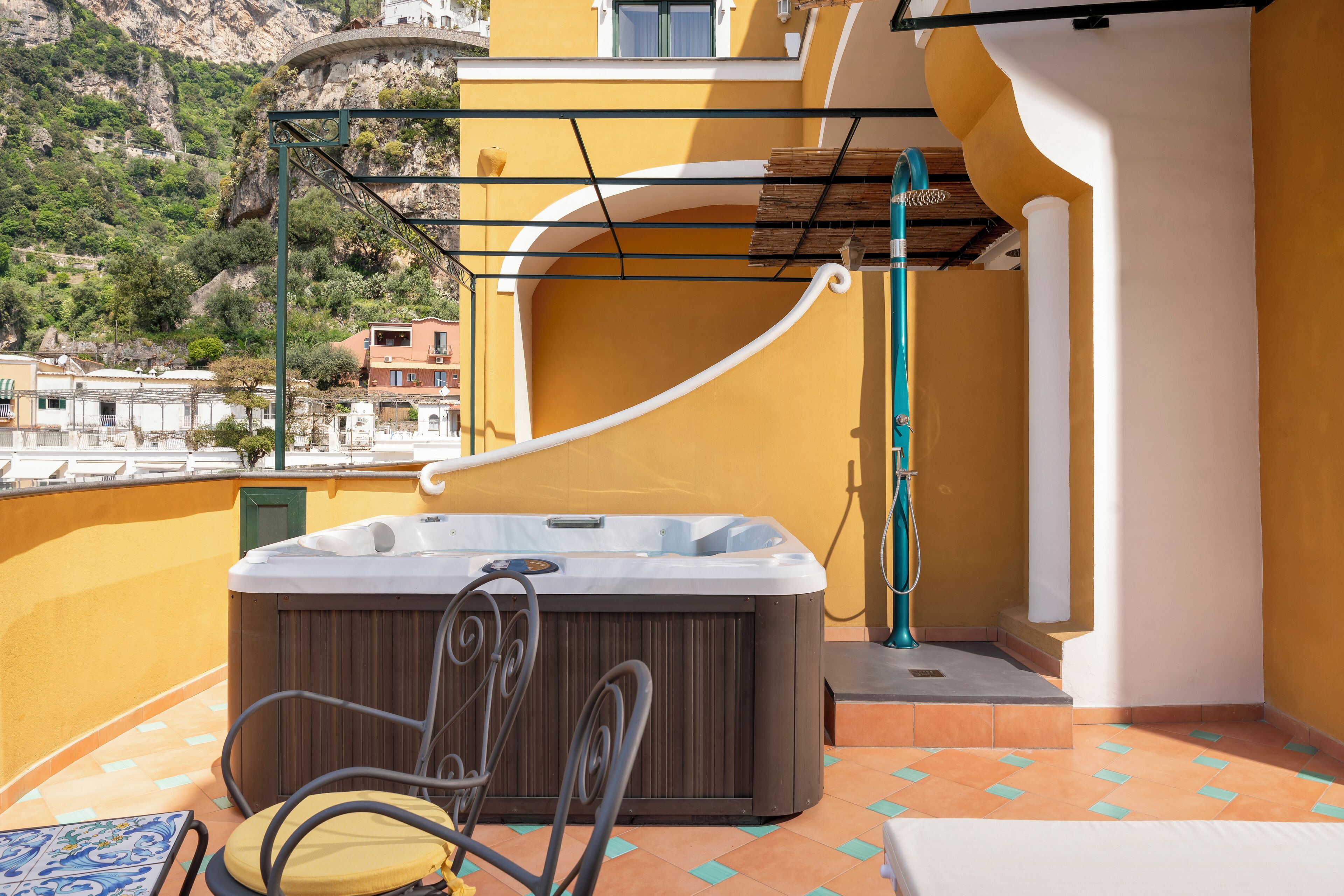 Un balcon doté d’un jacuzzi, de sièges et offrant une vue sur les bâtiments environnants.