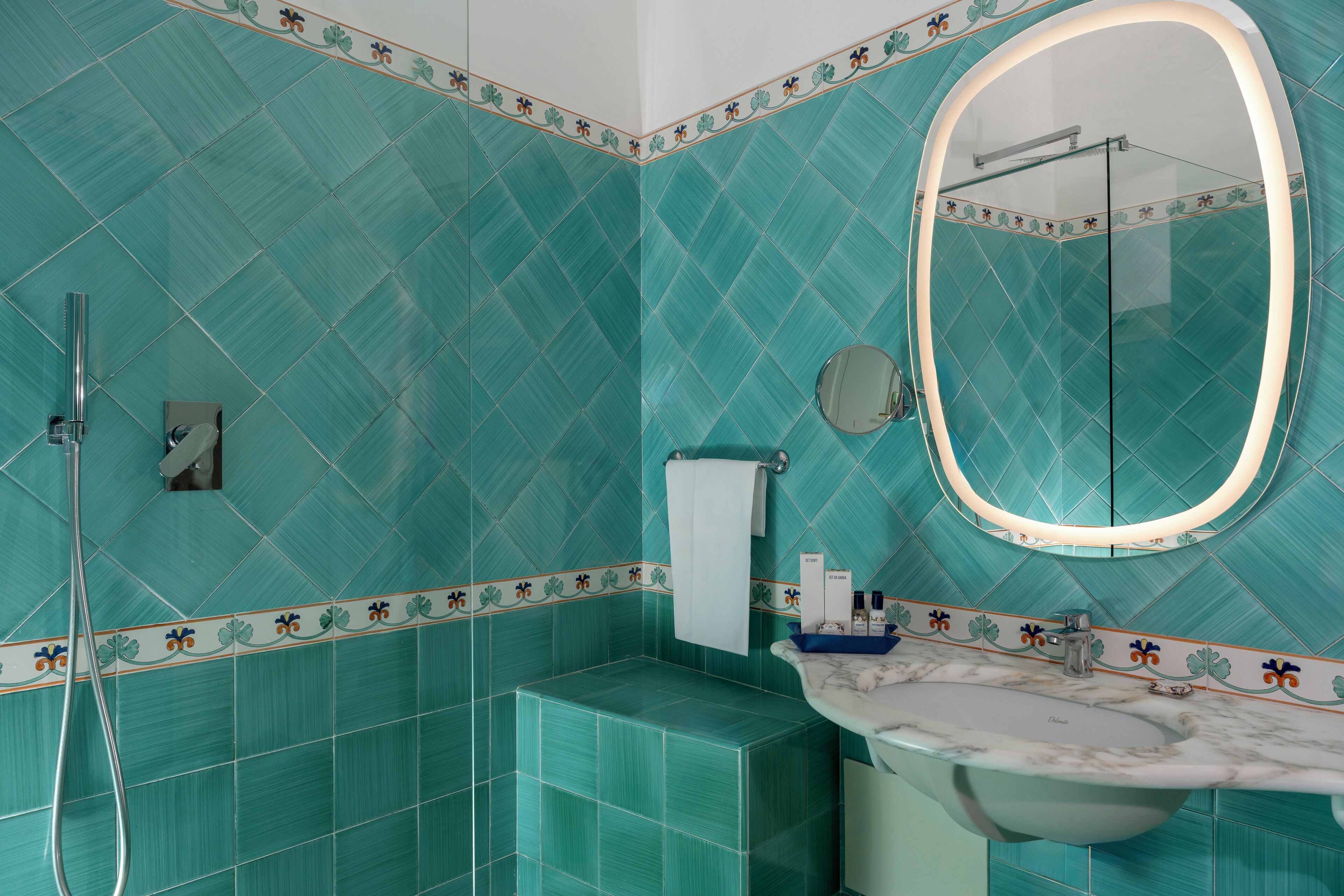 Une salle de bain avec un grand miroir, un lavabo et une douche.