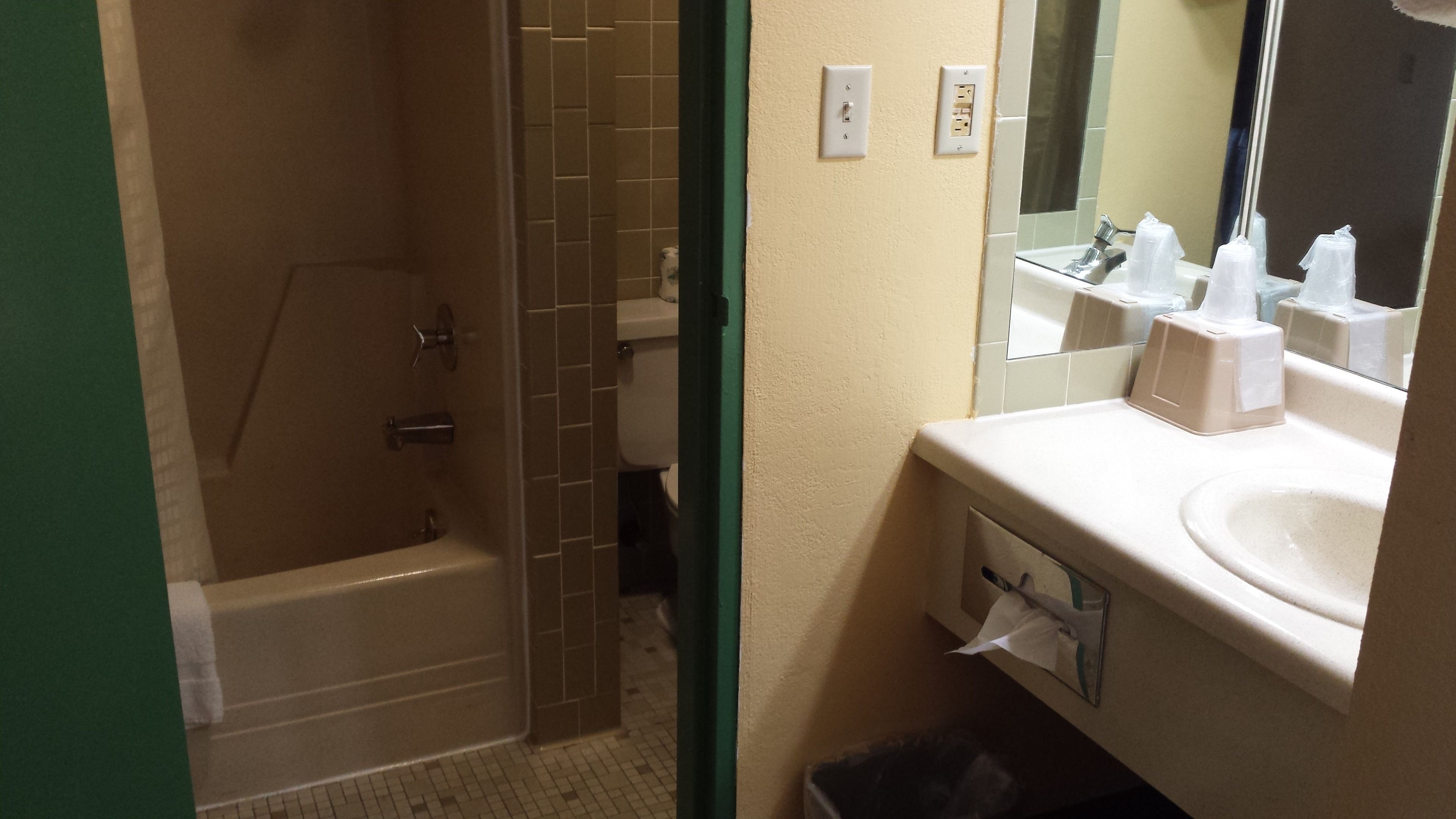 Un baño con bañera, inodoro, lavamanos y espejo.