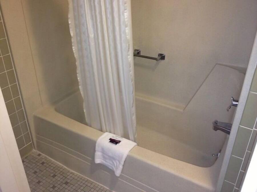 Un baño con bañera, cortina de ducha y un perchero para toallas.