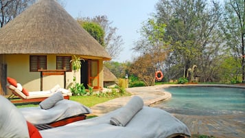 Relax in a serene setting with a lounge chair and pool access.