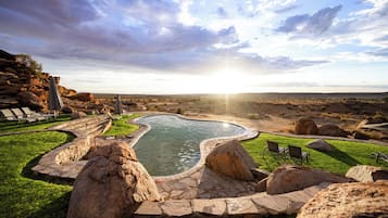 Een buitenzwembad en ligstoelen