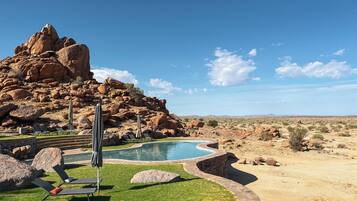 Een buitenzwembad en ligstoelen