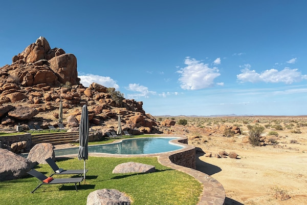 Una piscina al aire libre, sillones reclinables de piscina