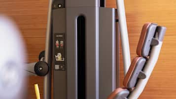 A leg press machine with a control panel, a padded seat, and a metal frame.