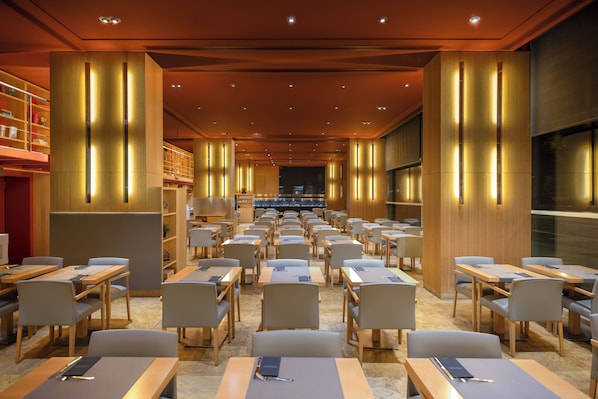 A conference room with rows of tables and chairs, a stage at the front, and bookshelves along the walls. - Hotel SB Diagonal Zero 4 Sup (Barcelona)