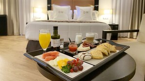 A breakfast tray with fruits, pastries, and beverages on a table in a hotel room. - Gran Hotel Don Manuel (Cáceres)