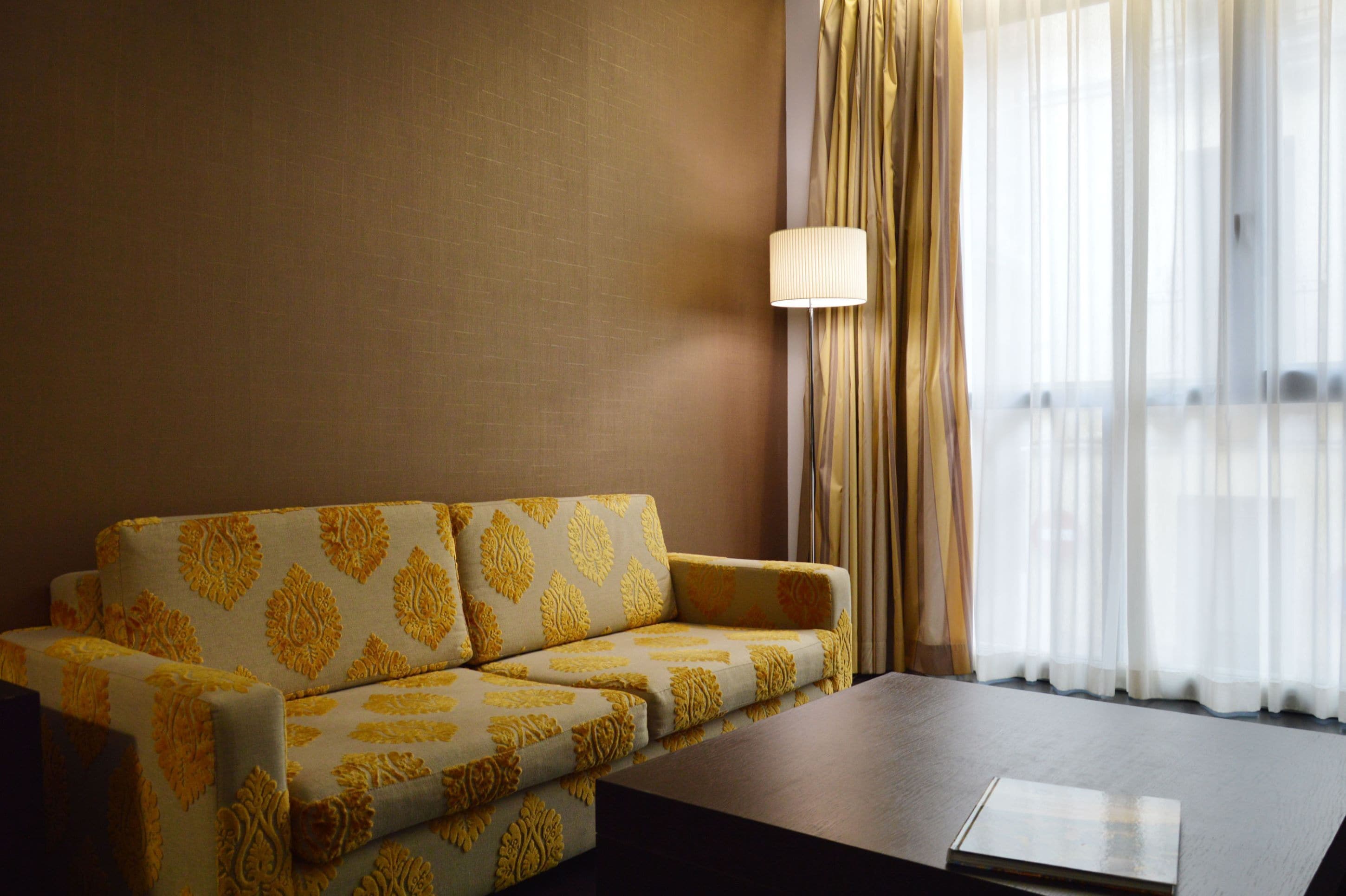 A hotel room with a sofa and a coffee table.