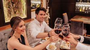 A dining area with a bar and a large wine bottle display. - Gran Hotel Don Manuel (Cáceres)