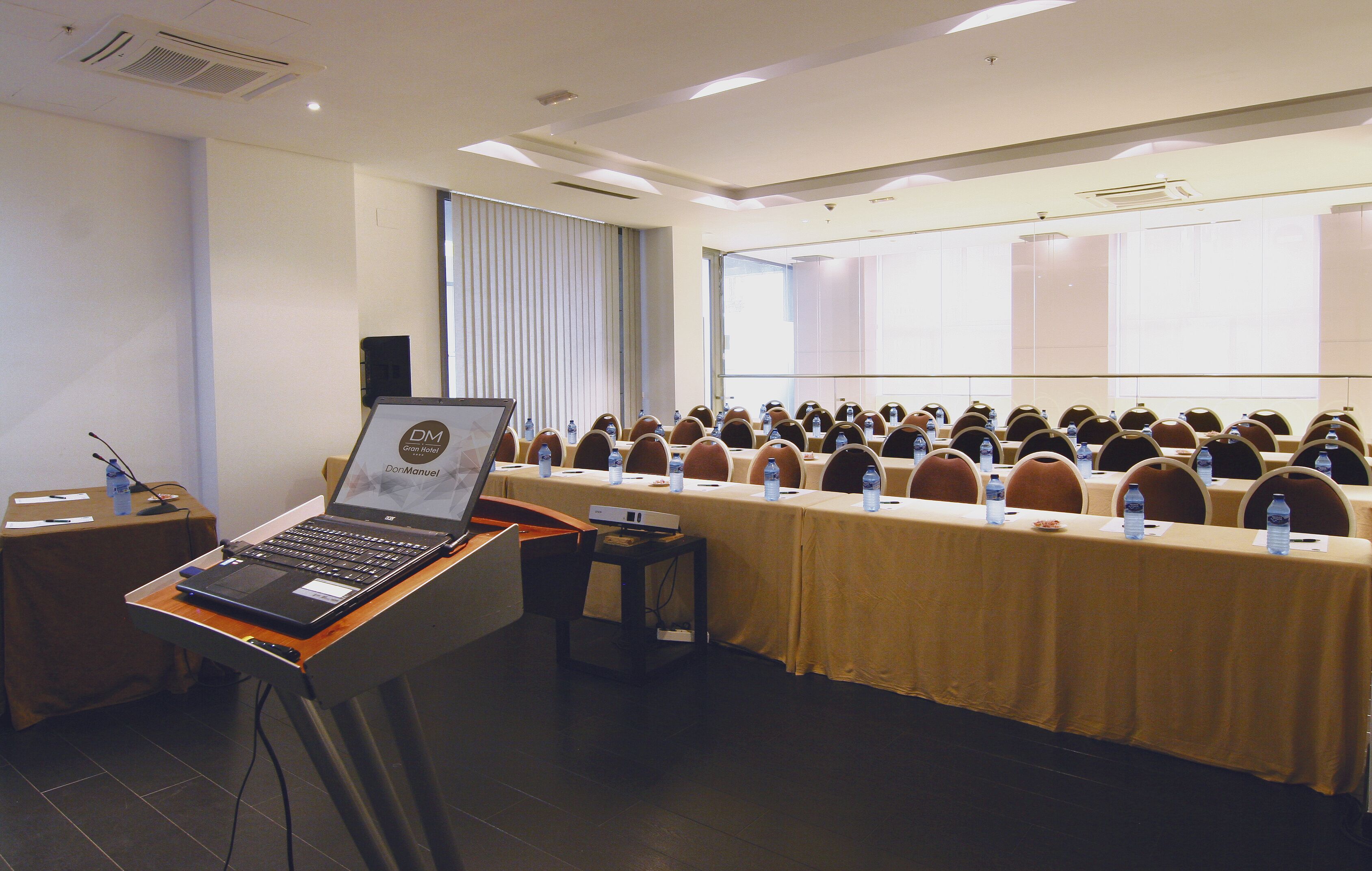 A conference room with a long table, laptops, and water bottles.