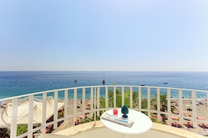 A balcony with a view of the sea, beach umbrellas, and a table with a book and a glass. - Albatros Beach Hotel - Letojanni (Letojanni)