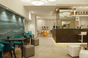 A modern interior with teal and gray seating, a bar area with bottles, and a large wall with a wavy pattern. - Albatros Beach Hotel - Letojanni (Letojanni)