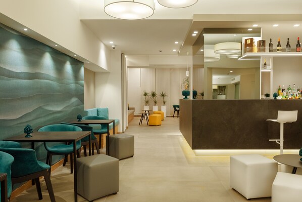 A modern interior with teal and gray seating, a bar area with bottles, and a large wall with a wavy pattern. - Albatros Beach Hotel - Letojanni (Letojanni)
