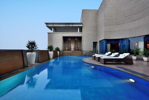 Una piscina al aire libre, sillones reclinables de piscina