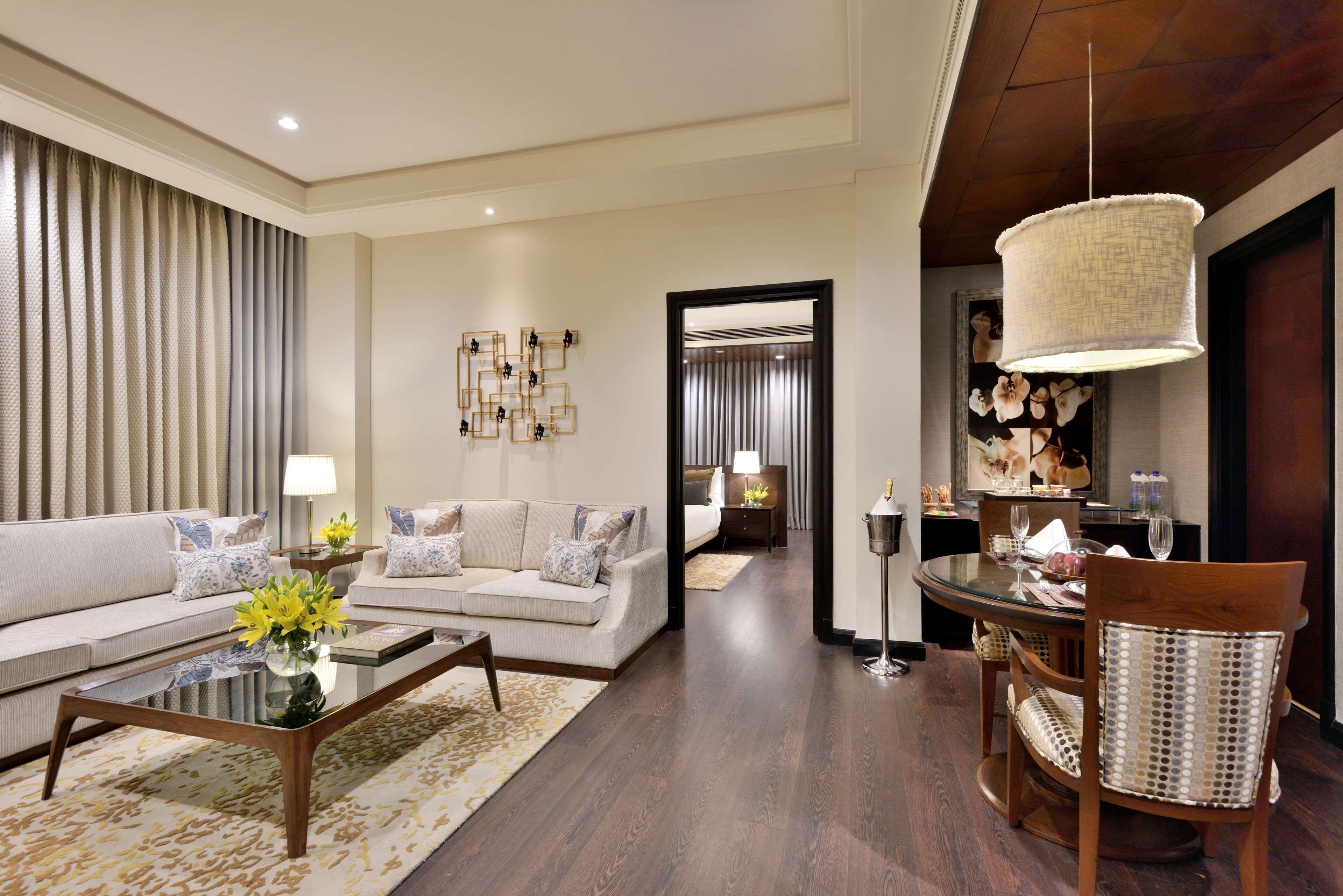 A modern living room with a sofa, coffee table, and dining area with chairs.