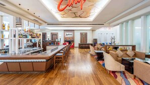 A spacious hotel lobby with a bar area, seating, and a ceiling mural. - Radisson Noida (Noida)