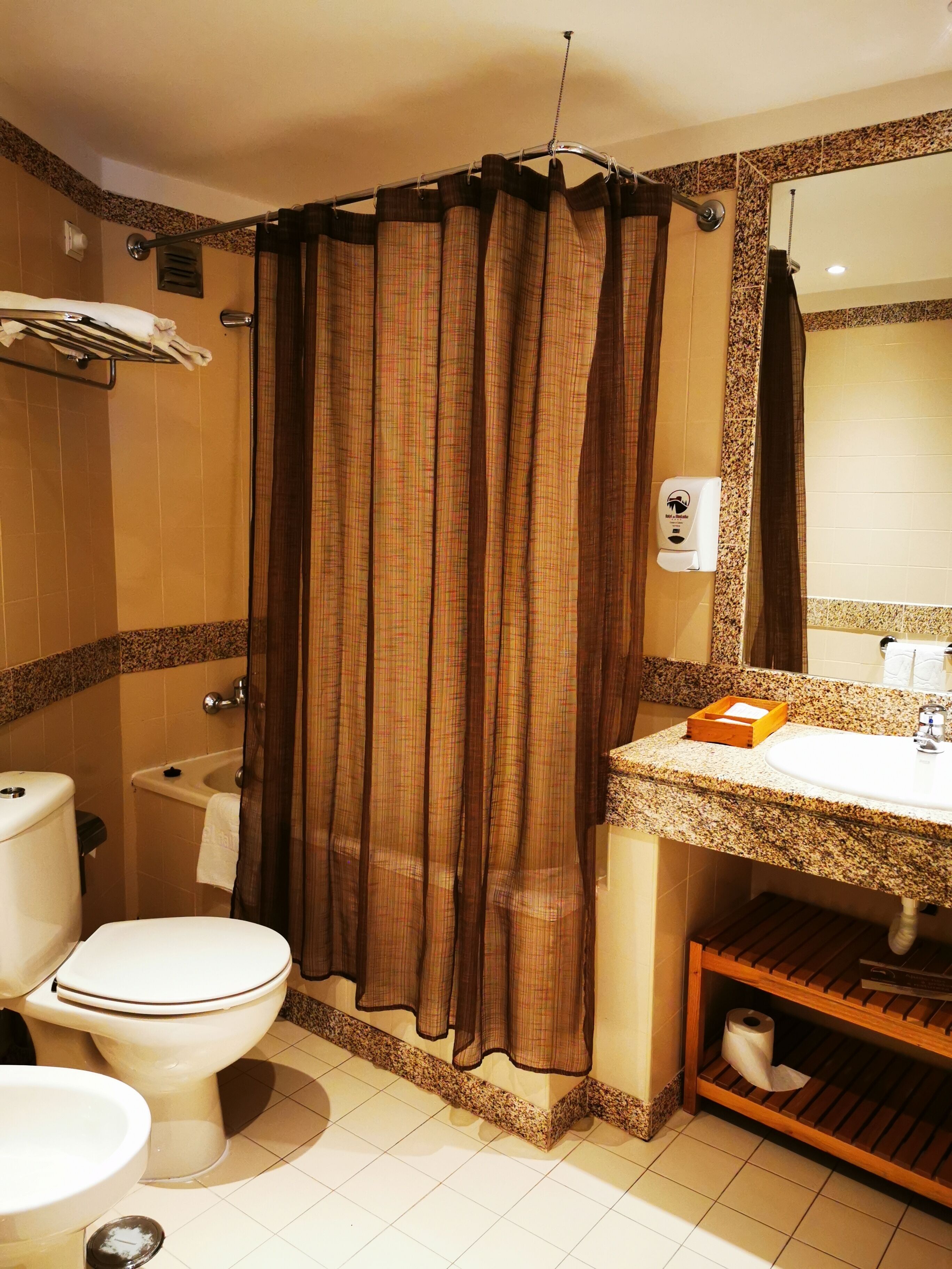 A bathroom with a toilet, sink, and shower curtain.