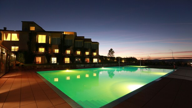 Un edificio moderno con piscina al anochecer.