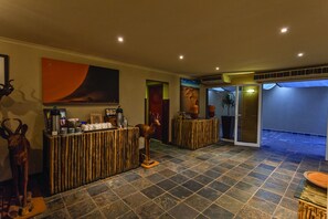 A lobby with a reception desk, a large painting, and a statue.