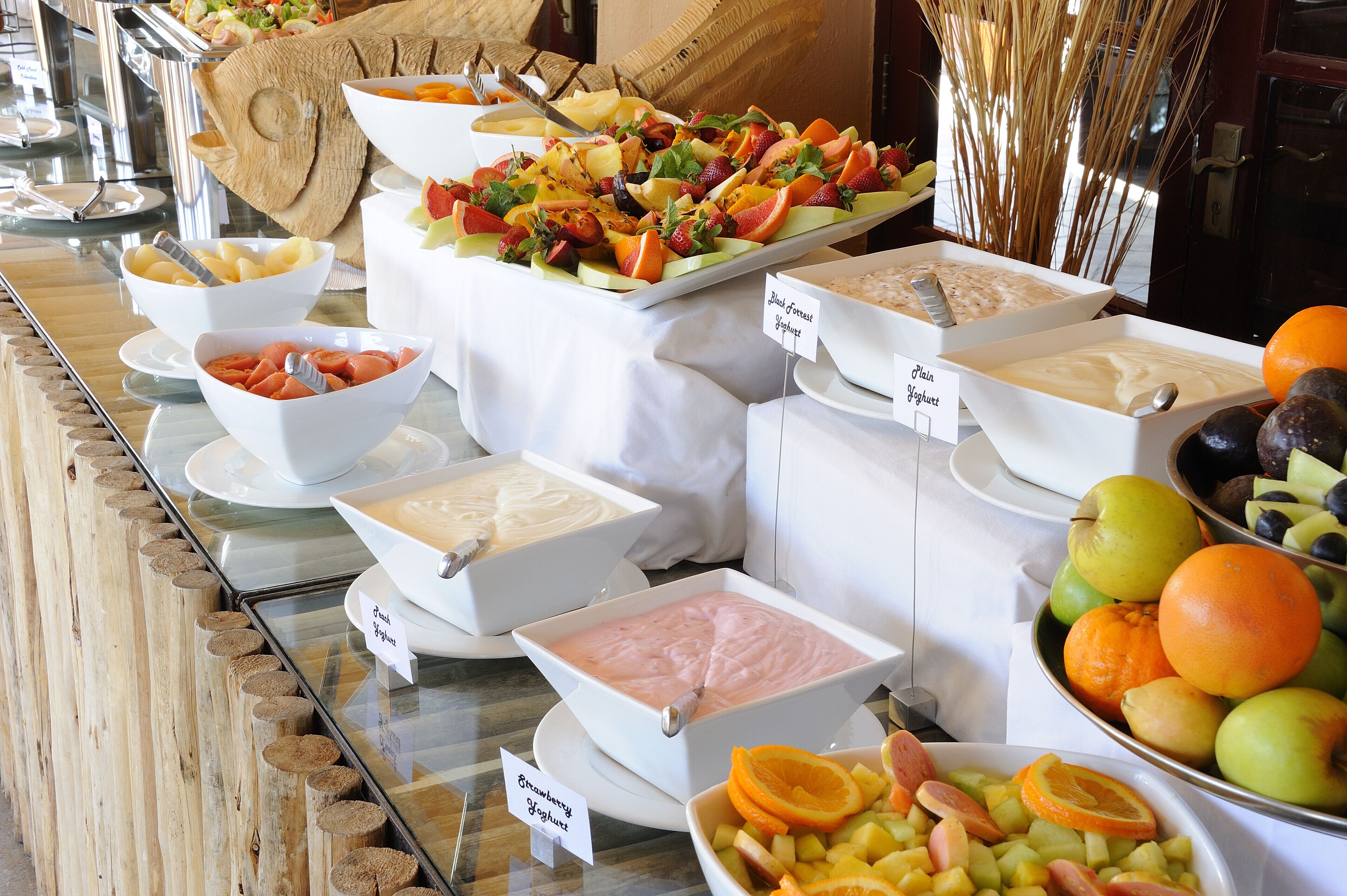 Een buffet met diverse gerechten en containers met labels.