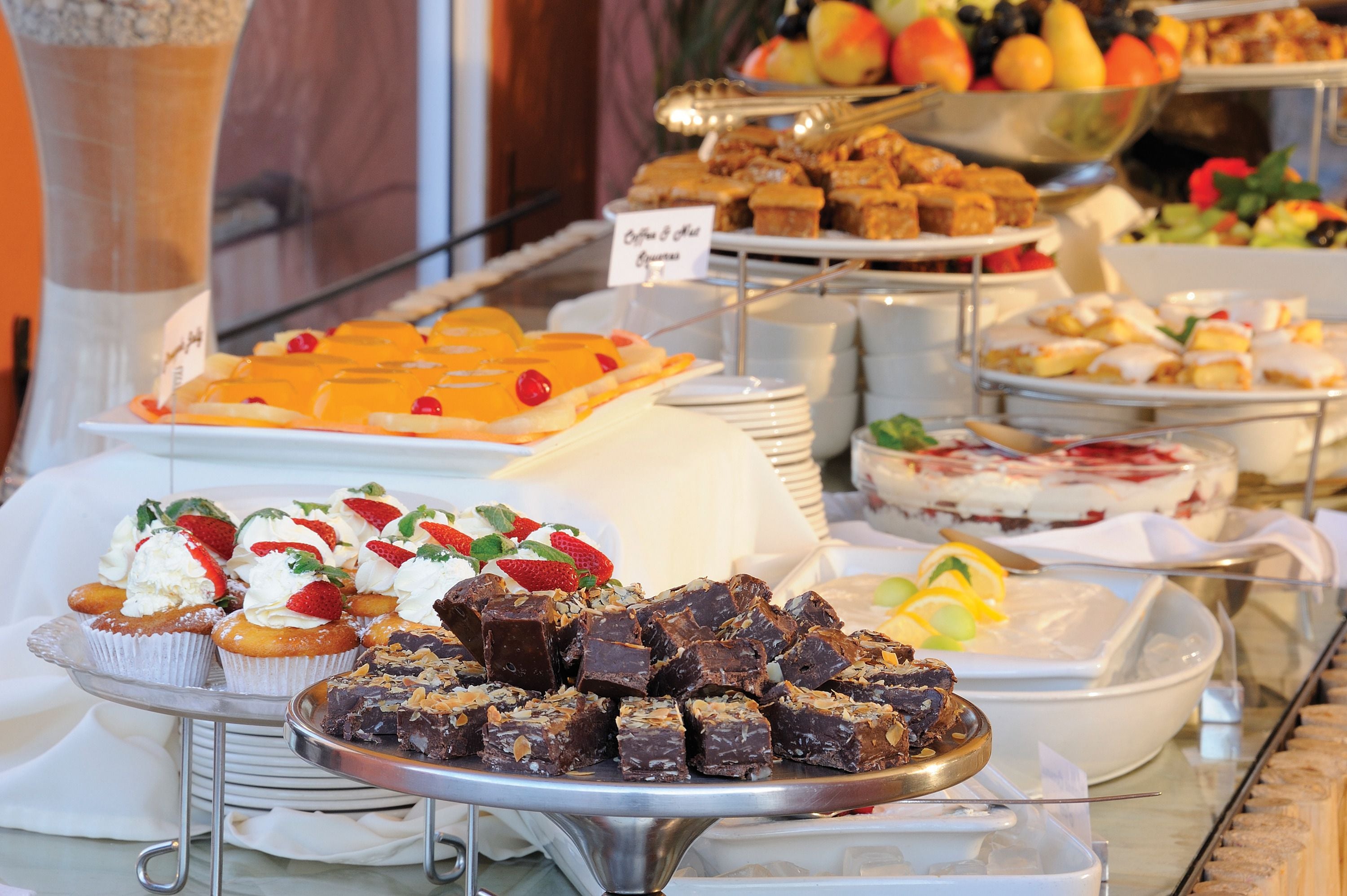 A buffet with various desserts and fruits.