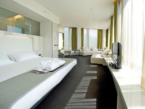 Habitación superior, 1 cama King size | Edredón, minibar, caja de seguridad en la habitación y escritorio 