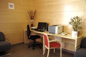 Un espacio de trabajo con escritorio, computadora, impresora y dos sillas.