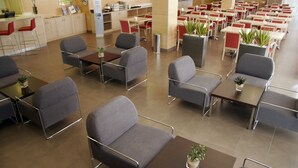 A spacious indoor area with multiple tables and chairs, some with potted plants. - Holiday Inn Express Madrid - Getafe by IHG (Getafe)