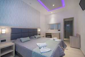 Een moderne slaapkamer met een groot bed, nachtkastjes, een inbouwkleerkast en een badkamer met spiegel.