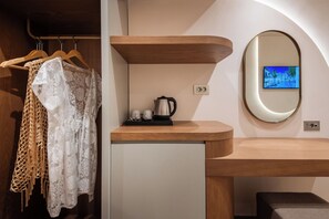 A modern bathroom with a wooden vanity, a mirror, and a television mounted on the wall. - Tzante Hotel Zakynthos Adults Only (Zakynthos)