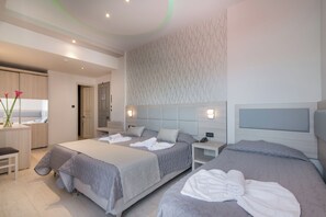 Een moderne hotelkamer met twee bedden, een zithoek en een badkamer.