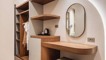 Un baño moderno con tocador de madera, un espejo y una estantería empotrada.