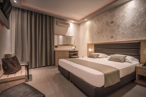 A hotel room with a large bed, a desk, a chair, a wardrobe, and a mirror. - Tzante Hotel Zakynthos Adults Only (Zakynthos)