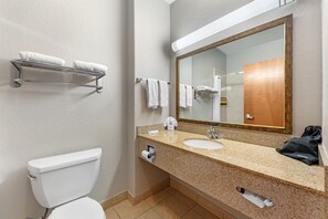 Een bad/douchecombinatie, een haardroger, handdoeken