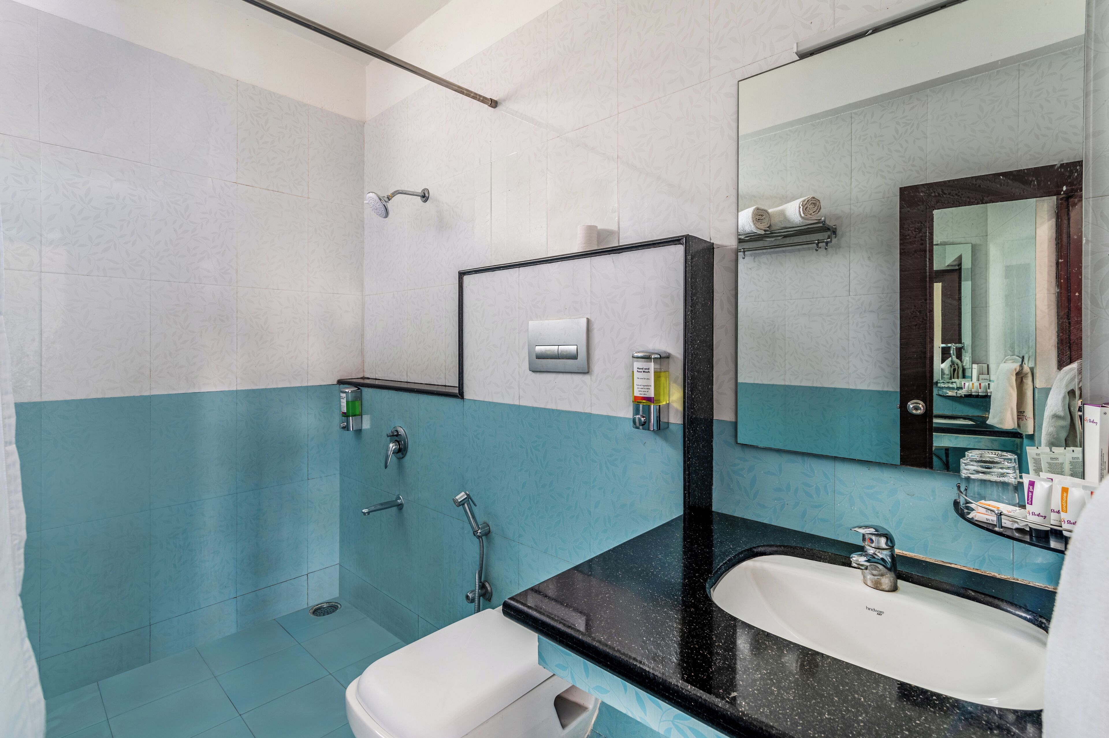 A bathroom with a white sink, a mirror, and a shower.