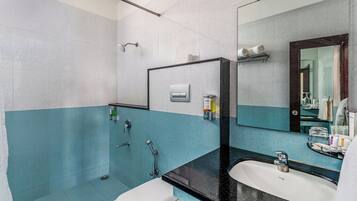 A bathroom with a white sink, a mirror, and a shower.