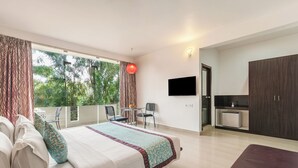 A hotel room with a bed, a desk, a chair, a TV, and a wardrobe. - Sterling Yelagiri (Tirupattur)