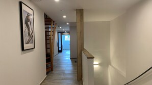 A hallway with a staircase, a wooden handrail, and a framed picture on the wall. - Gästehaus Elisabeth (Tulfes)