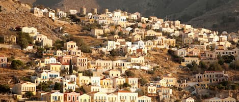 A coastal town with buildings built on a hillside, overlooking the sea.