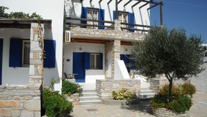 A traditional white building with blue shutters and stone walls.