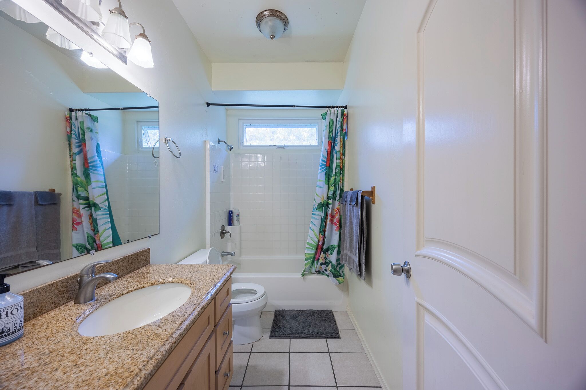 A bathroom with a sink, toilet, and shower area.