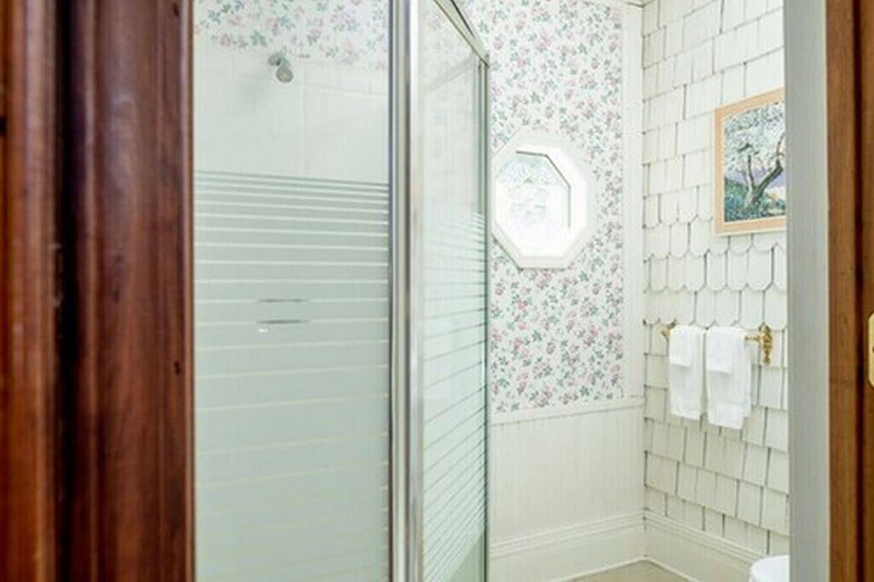 A bathroom with a shower, tiled walls, and a toilet.