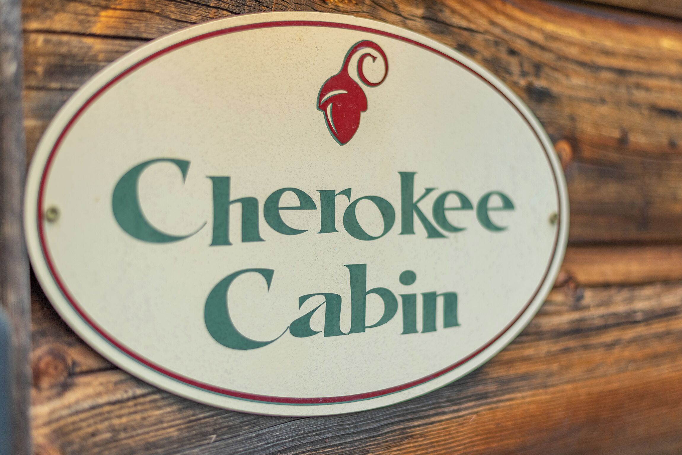 A circular sign with the text "Cherokee Cabin" and a red logo.