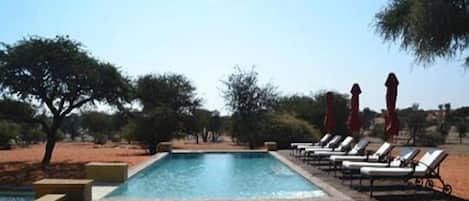 Una piscina al aire libre, tumbonas