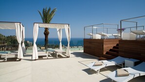 A rooftop terrace with white canopies, lounge chairs, and a view of the sea. - Hotel Il Piccolo Giardino (Taormina)