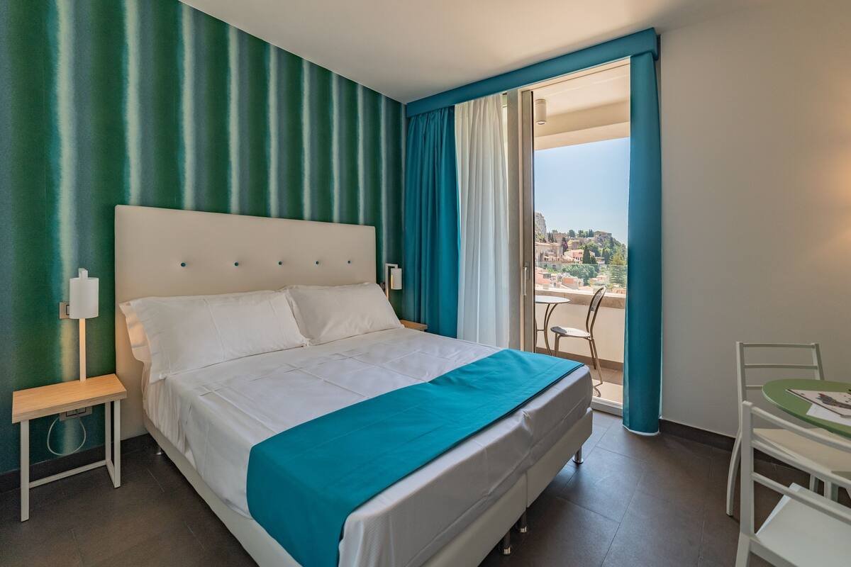 Une chambre d’hôtel avec un lit, une petite table et une chaise.