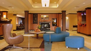 A lobby with a fireplace, seating area, and a reception desk.